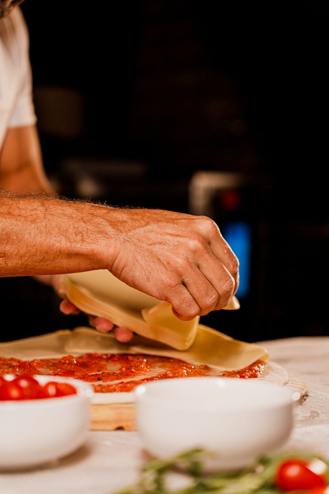 Hands stretching fresh mozzarella in a rustic workshop